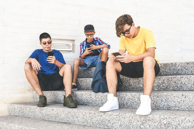 Teenagers friends using smartphone. teens playing online. boys watching video on mobile phone