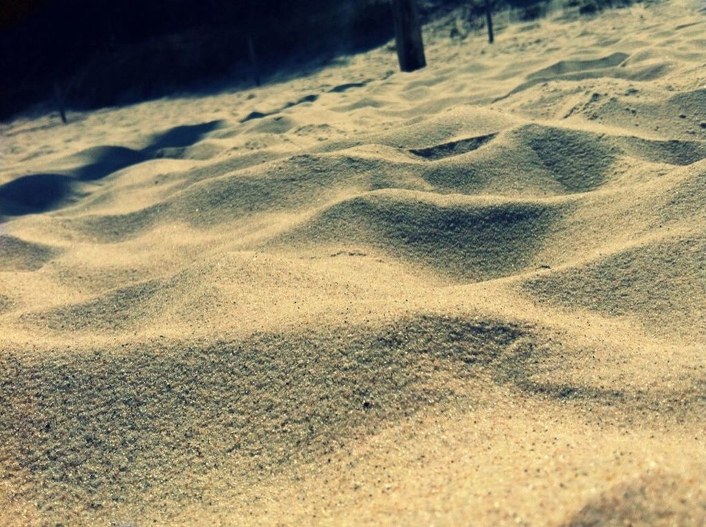 sand, beach, shadow, footprint, sunlight, high angle view, tranquility, shore, nature, day, outdoors, street, no people, asphalt, tranquil scene, road, landscape, sunny, textured, beauty in nature