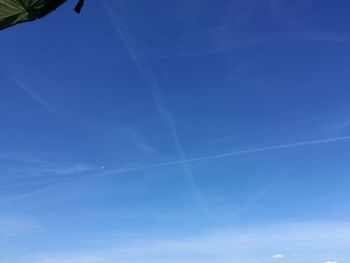 Low angle view of vapor trail in blue sky