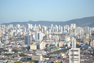 Aerial view of buildings in city against clear sky