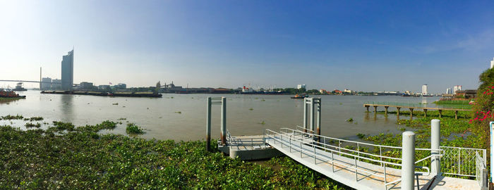 Scenic view of river by city against clear sky
