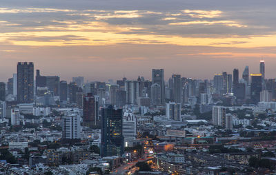 Aerial view of buildings in city against sky during sunset