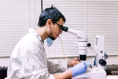 Male scientist using microscopy in laboratory