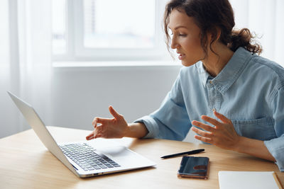 Young woman using laptop at table