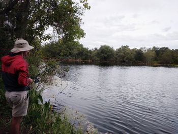 Silhouette of woman standing on lakeshore