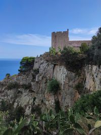 Old ruin building by sea against sky