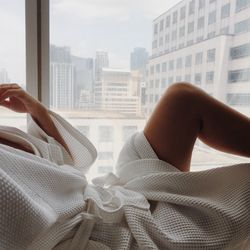 Woman relaxing in the bathing robe by the window
