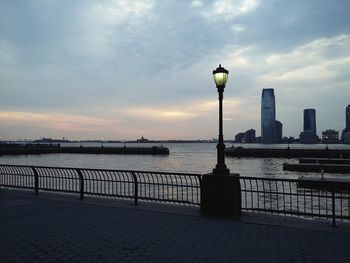 Bridge over river against cloudy sky