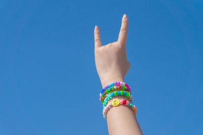 Midsection of woman against blue sky