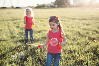 Girls on field against sky