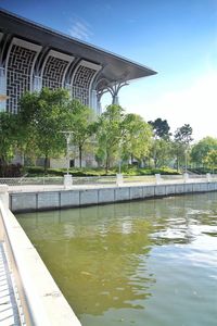 Swimming pool by lake against buildings in city