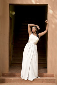 Portrait of woman standing against wall