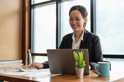 Young businesswoman using laptop at office