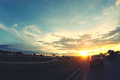 Cars on road at sunset