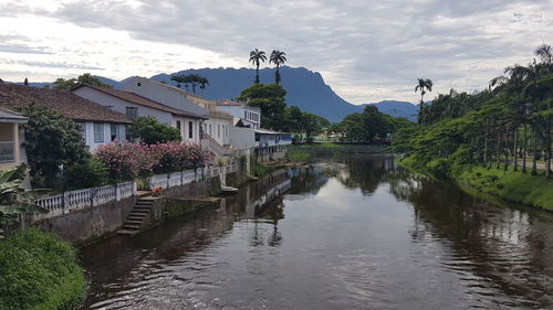 Scenic view of river by buildings against sky