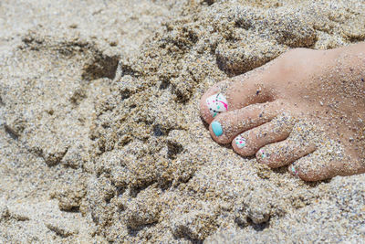 Low section of woman on sand at beach