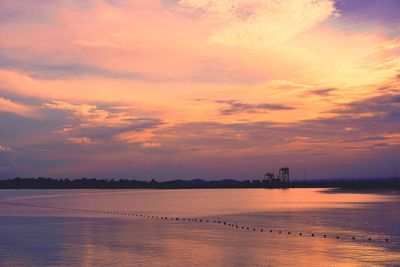 Scenic view of sea against cloudy sky during sunset