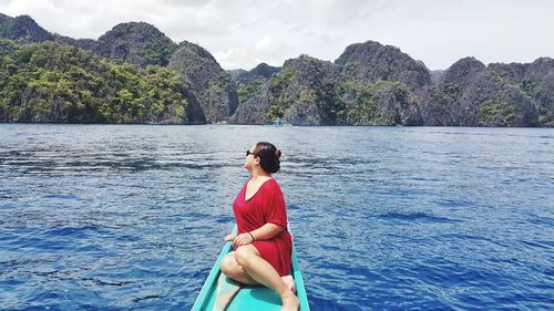 Full length of woman sitting on boat against sky