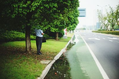 Rear view of man standing by road