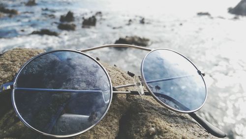 Close-up of sunglasses against sky