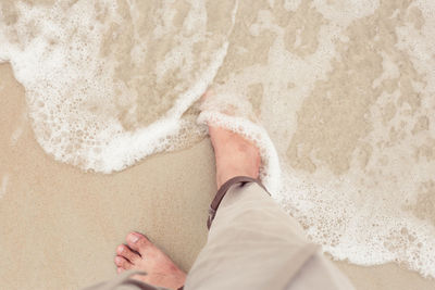 Low section of person on sand at beach