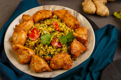 Food for suhoor in ramadan bulgur fast with beef in a plate on a blue napkin next to vegetables