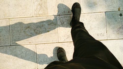 Low section of man standing on tiled floor