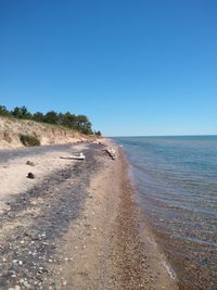 Scenic view of beach against clear blue sky