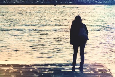 Rear view of woman standing on beach