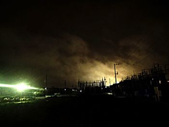 Illuminated street light against sky at night