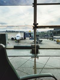 Airplane on airport runway against sky
