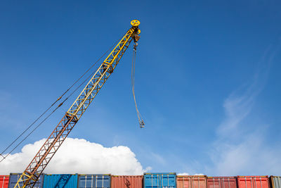 Low angle view of crane against blue sky