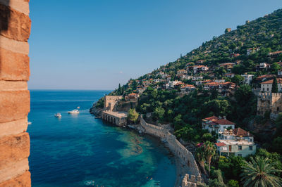 High angle view of townscape by sea against sky