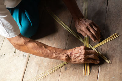 Cropped hands adjusting sticks on wooden floor
