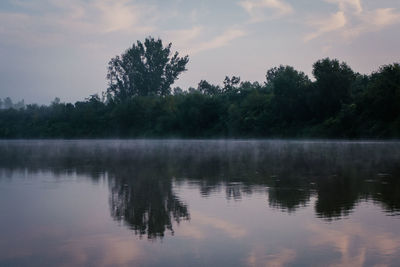 Reflection of trees in lake against sky