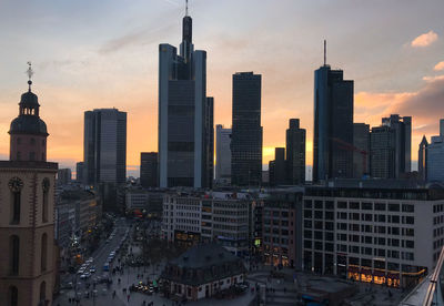 Skyscrapers in city against sky during sunset