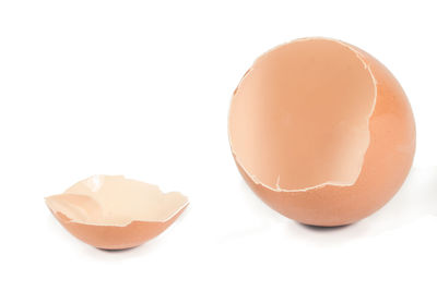 Close-up of broken egg against white background