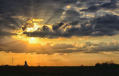 Silhouette of landscape against cloudy sky