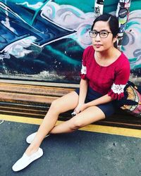 Portrait of young woman sitting outdoors