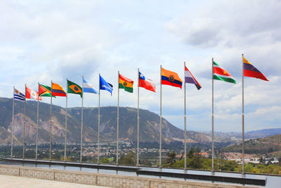 National flags by mountains against sky