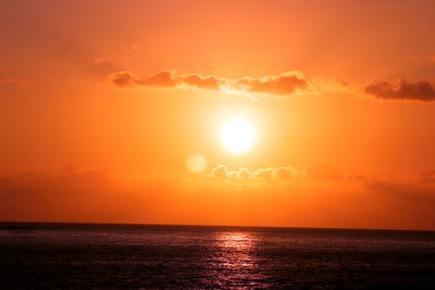 Scenic view of sea against orange sky