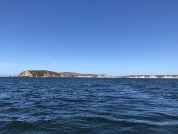 Scenic view of sea against clear blue sky