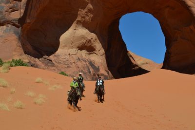  people riding horses at desert