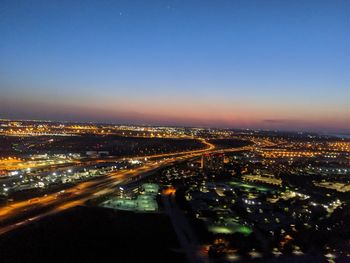 High angle view of illuminated city against sky at night