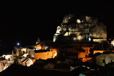 Illuminated buildings in city against sky at night