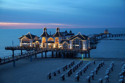 Built structure on beach against sky at dusk