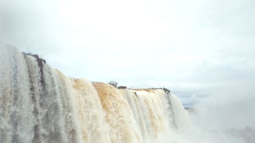 Scenic view of waterfall against sky during winter