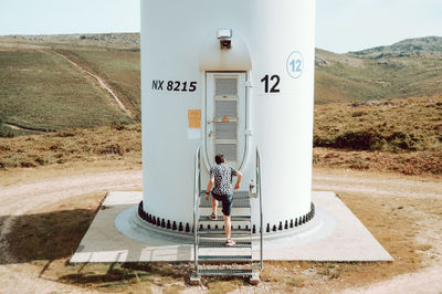 Rear view of man standing on road sign