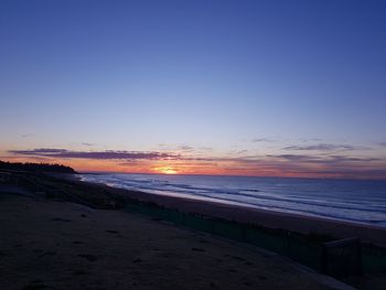 Scenic view of sea against clear sky at sunset