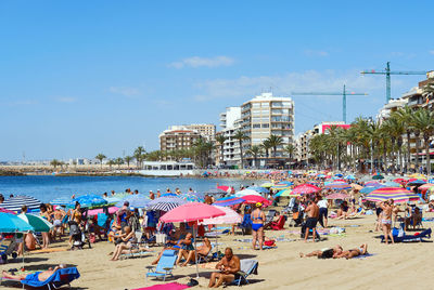 Group of people on beach against sky